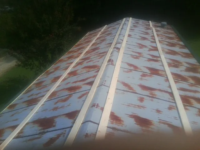 Rusted metal roof panels with new wood purlins before replacement — Storm Damage Roof Repair in Davisburg by Roofing Brothers