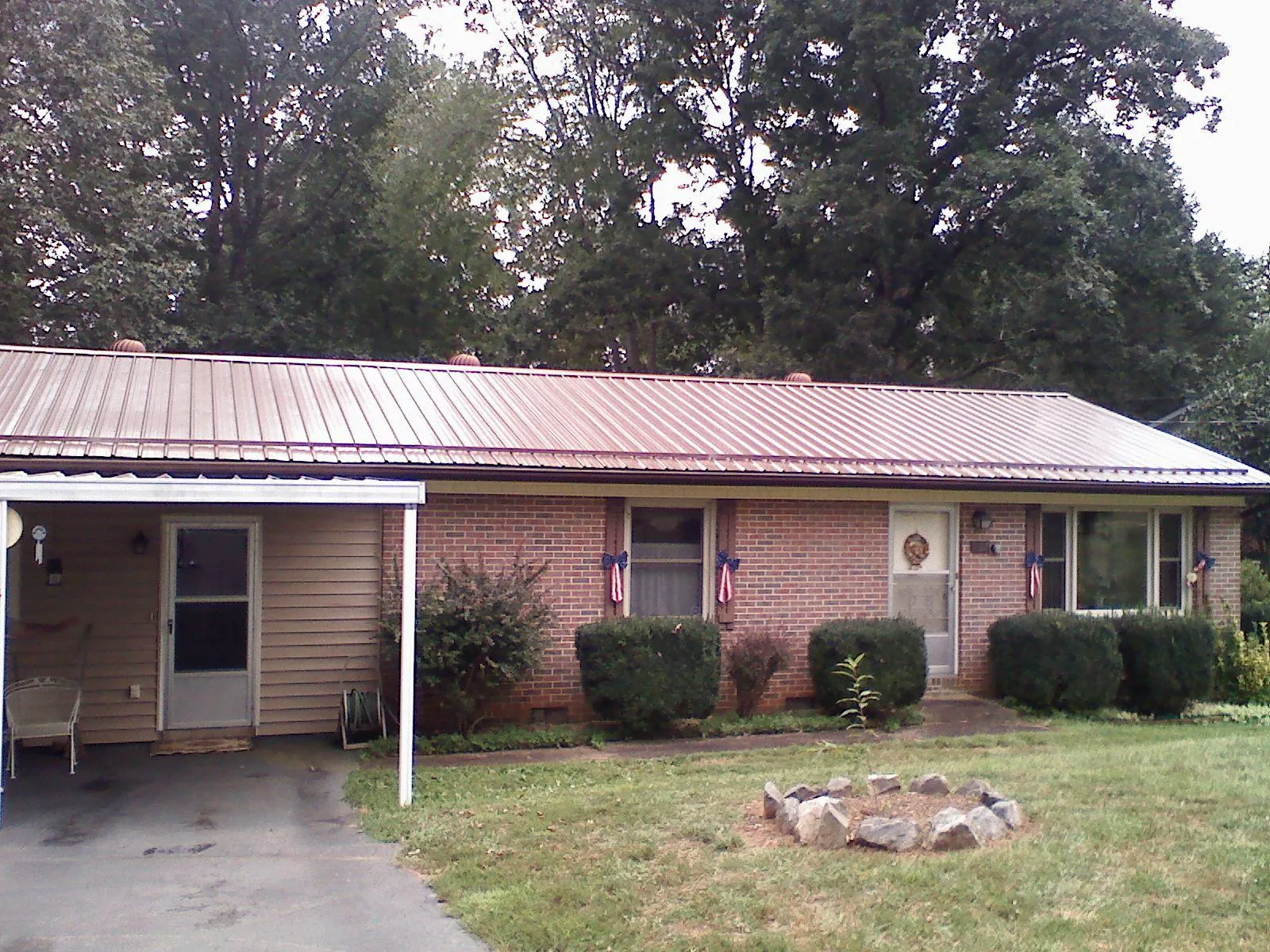 Bronze metal roof and carport on a brick ranch home — Roof Repair work by our crew in Davisburg