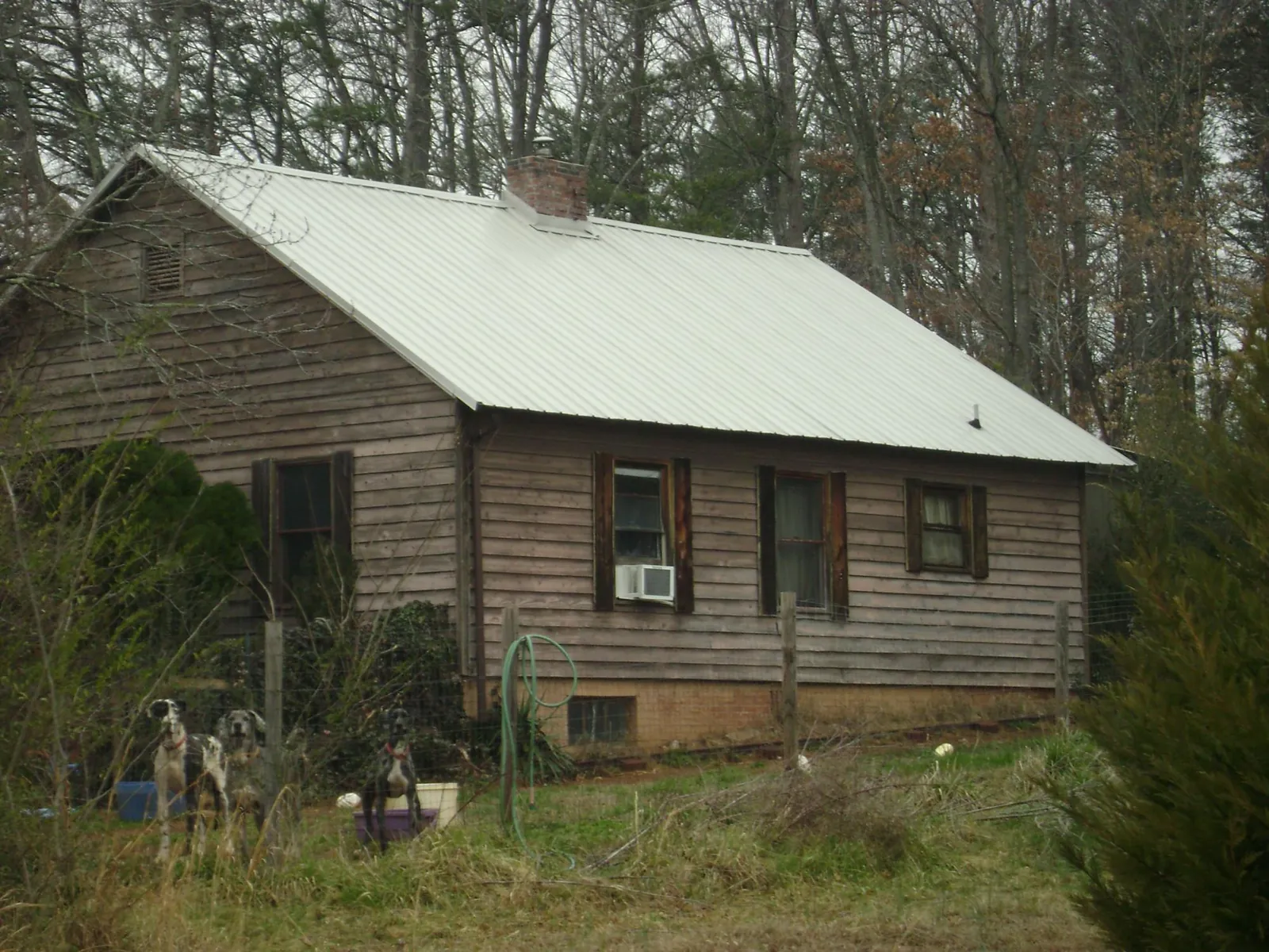 White metal roof on an old wood sided farmhouse, from a Metal Roof Installation job in Davisburg